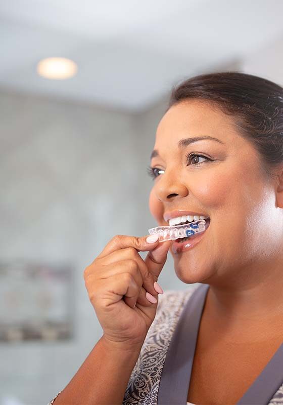 A woman inserting a Perio Tray® by Perio Protect A woman using a Perio Tray® by Perio Protect